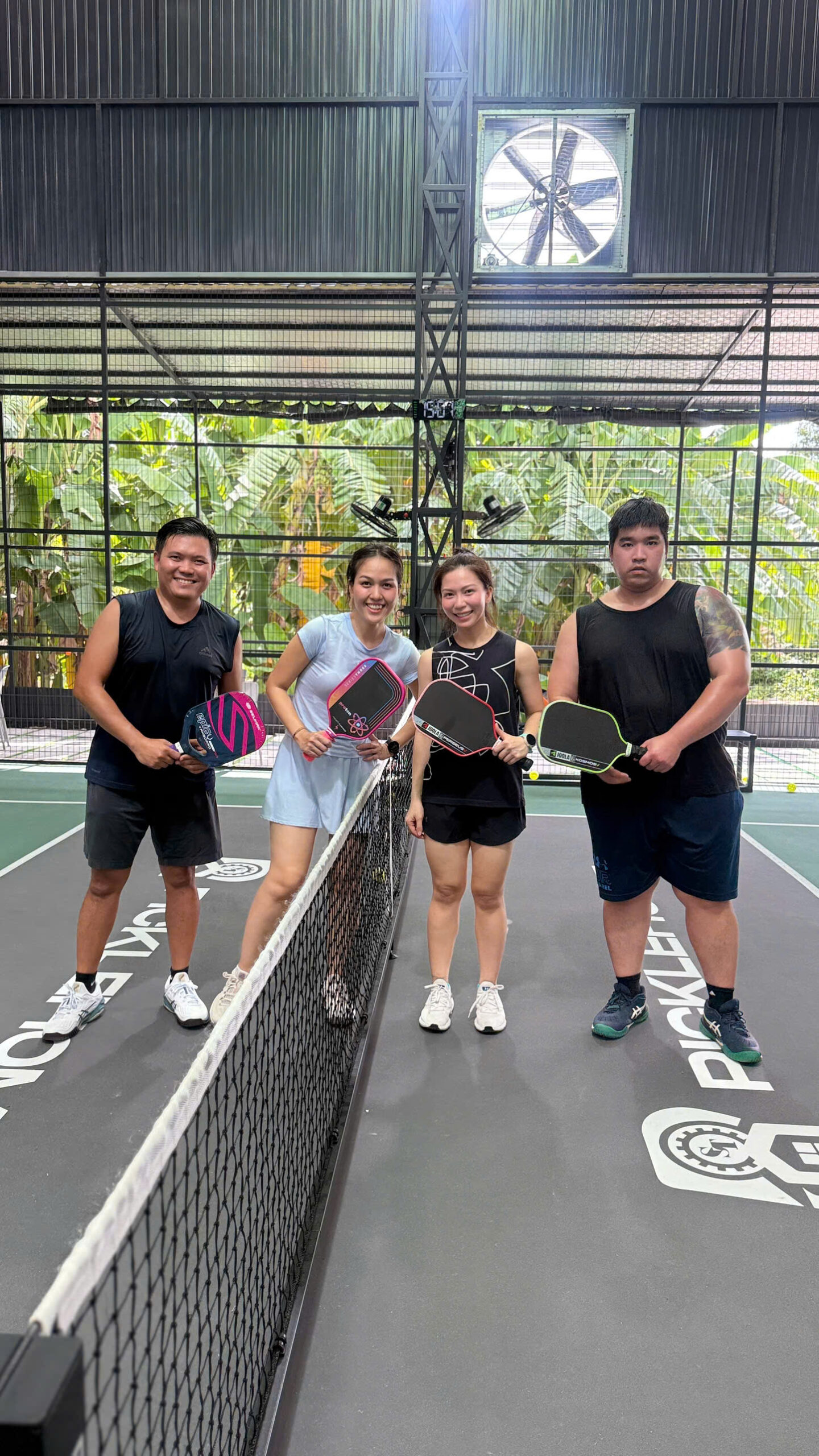 Nhóm người chơi Pickleball đứng ở hai bên lưới để tập vị trí và phối hợp đánh đôi